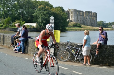 Cystadleuydd blaenorol Ironman ar y cwrs beic ger Caeriw