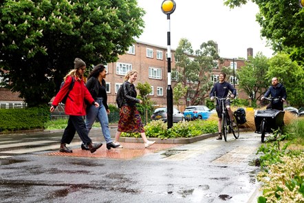 People walk and cycle on Benwell Road, within the Highbury LTN. The crossing also forms part of the Cycleway 38 route.