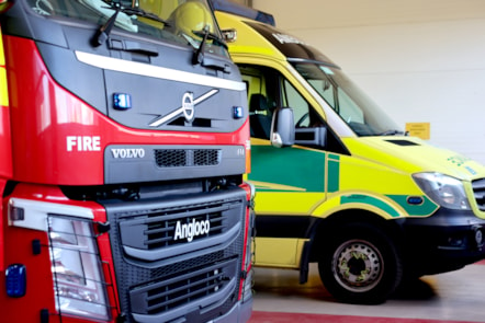 Front side view of an ambulance and a fire engine parked next to each other.