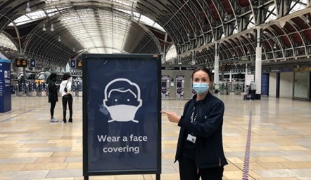 Network Rail employee with face coverings sign at Paddington station: Credit: Network Rail