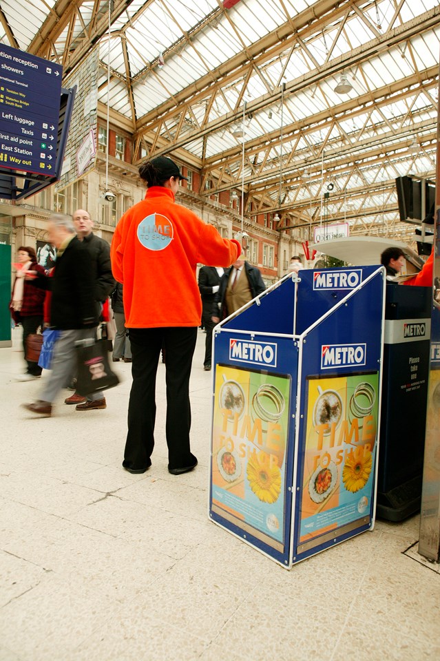 Time to Shop 3: One of Network Rail's 'Time to Shop' team gives discount leaflets to busy Christmas shoppers at Waterloo station