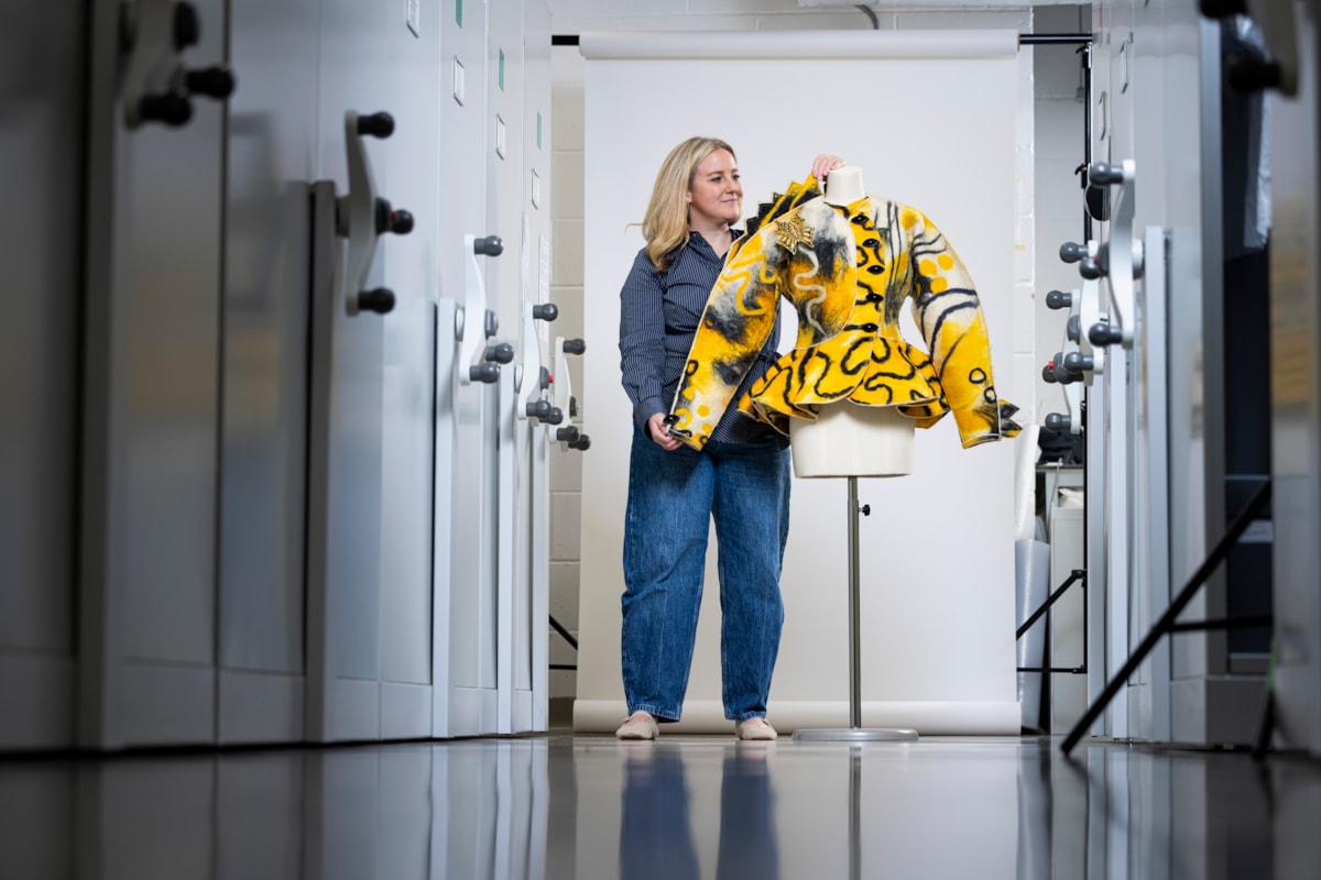 Curator Lisa Mason examines a yellow jacked designed by Jean Muir. Photo © Duncan McGlynn (1)