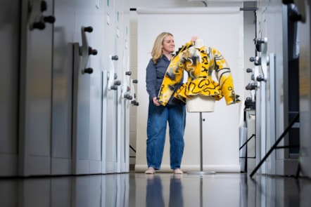 Curator Lisa Mason examines a yellow jacked designed by Jean Muir. Photo © Duncan McGlynn (1)