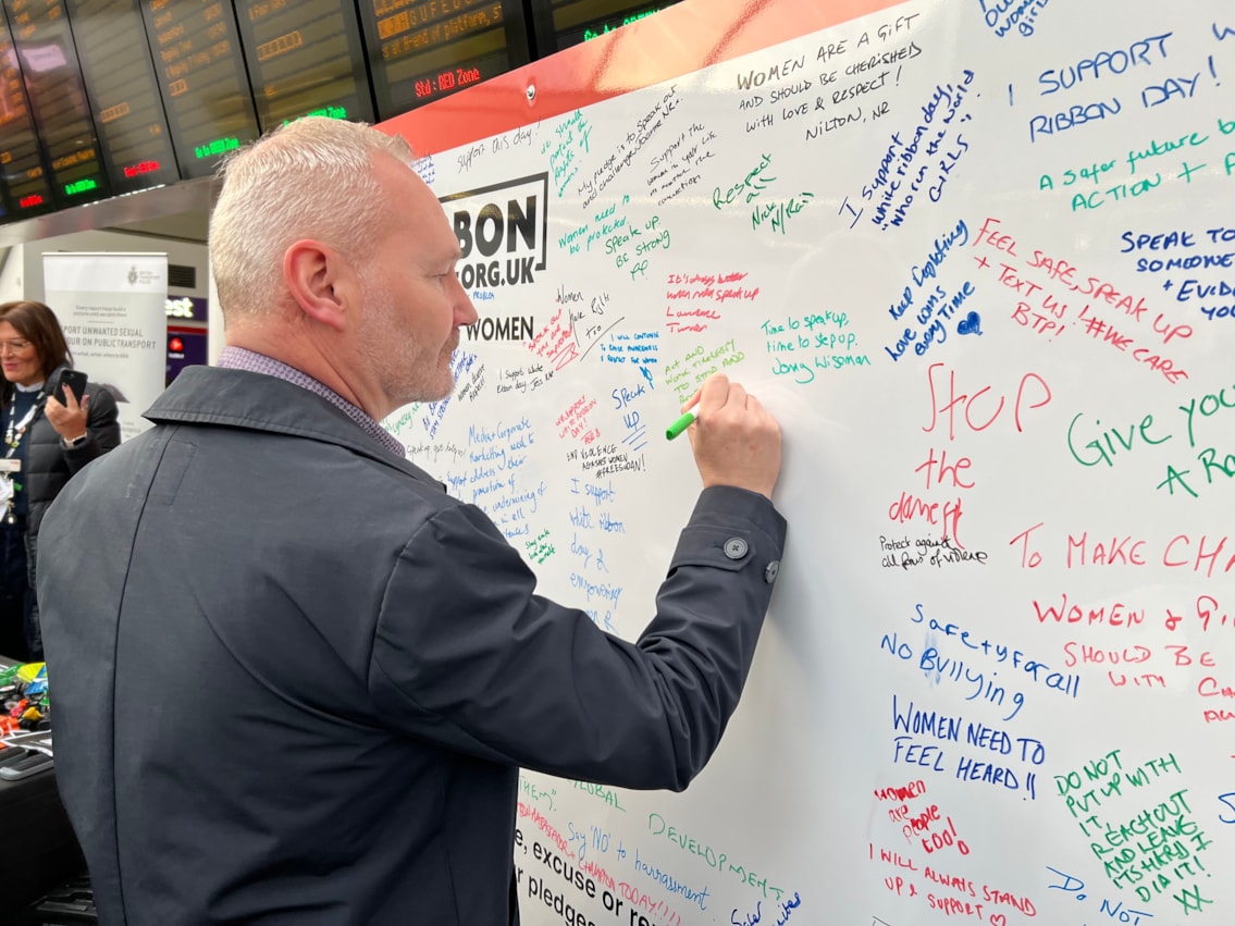 Mal Drury-Rose, director of rail for Transport for West Midlands, signing the White Ribbon pledge wall