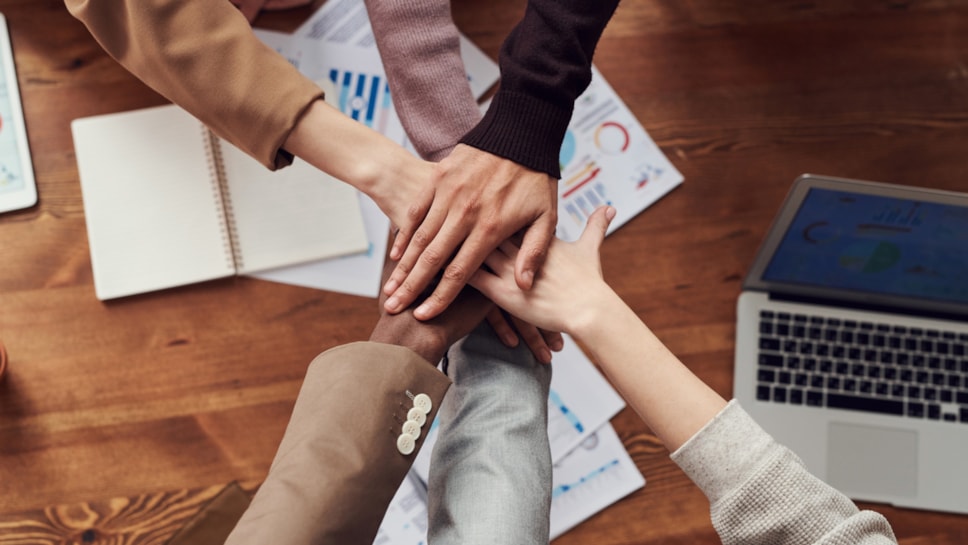 people's hands over a work desk