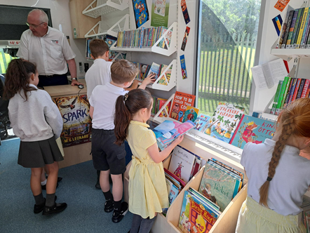 Pupils from Woodland Community Primary School in Skelmersdale with support manager for cultural services Dawn Child enjoy the books in the school mobile bus which has come to visit.