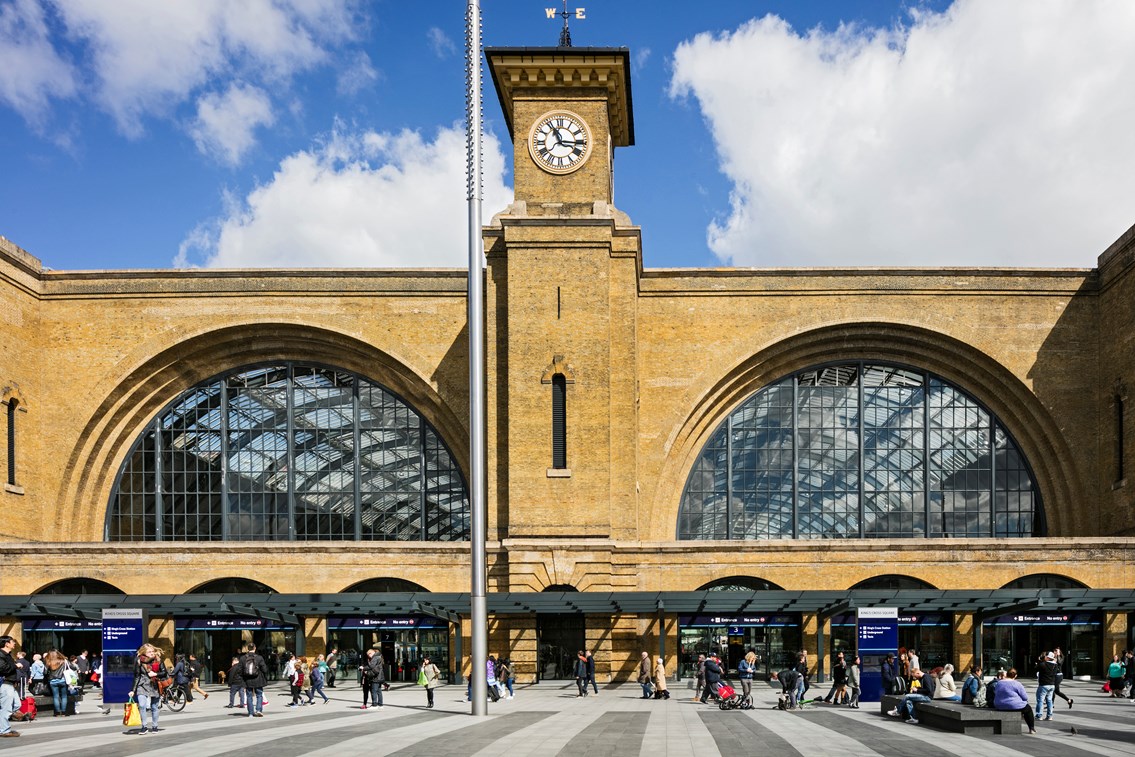 King's Cross railway station - long distance with clock tower: King's cross railway station
clock tower
king's square
train station
busy
people
crowds
day
