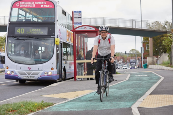 Cycling on York Road-2: Image shows a cyclist in a cycle lane alongside a bus on York Road in Leeds.