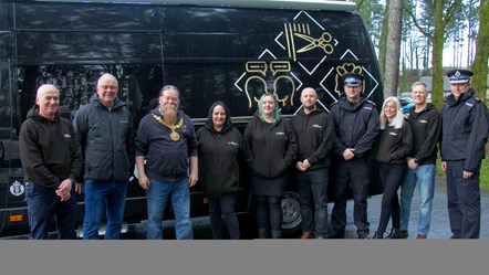 Ten people standing in front of mobile hairdressing van