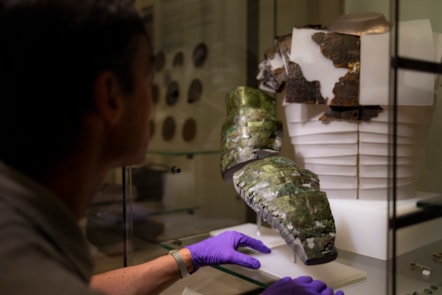 Dr Fraser Hunter installs the Roman arm guard in the Early People gallery at the National Museum of Scoltand. Image copyright Duncan McGlynn (4)