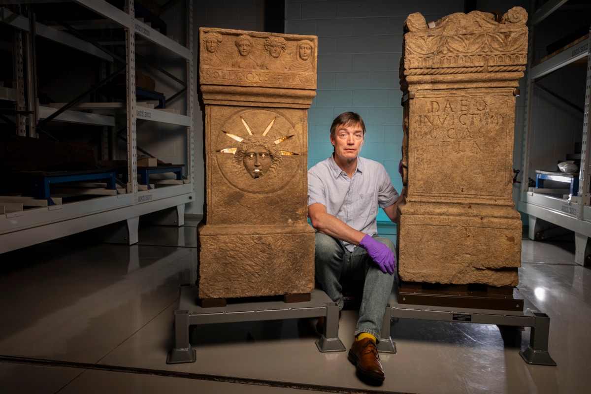 Curator Dr Fraser Hunter examines the Roman altars.Photo © Duncan McGlynn (1)
