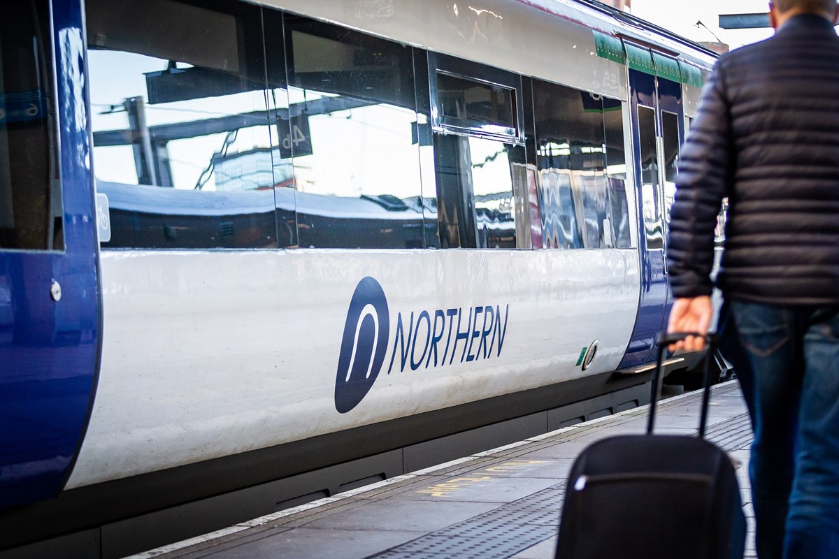 Image shows Northern train at platform with customer on the platform