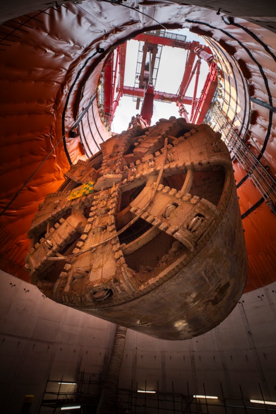 TBM Sushila removed after completing 5-mile drive from West Ruilsip to Green Park Way: Photograph of Tunnel Boring Machine (TBM) ‘Sushila’ being lifted out of the ground at the Green Park Way site in Greenford, West London captured from a tunnel adit connecting Green Park Way's main and auxiliary shafts.
 
The cutterhead, front and middle shield, weighting 880 tonnes, were lifted from the vent shaft in one piece on Saturday, March 15, using a 750 tonne gantry crane. The TBM – with a cutterhead spanning 9.48 metres in diameter – was launched from West Ruislip in October 2022 and completed its journey in December 2024. TBM Sushila excavated over 1.2 million tonnes of earth and installed 4,217 tunnel rings.
 
TBM Sushila was used to construct part of the Northolt Tunnel – an 8.4-mile tunnel being built by four TBMs which will take HS2 trains from Old Oak Common Station to the outskirts of the capital.

Copyright - HS2 Ltd