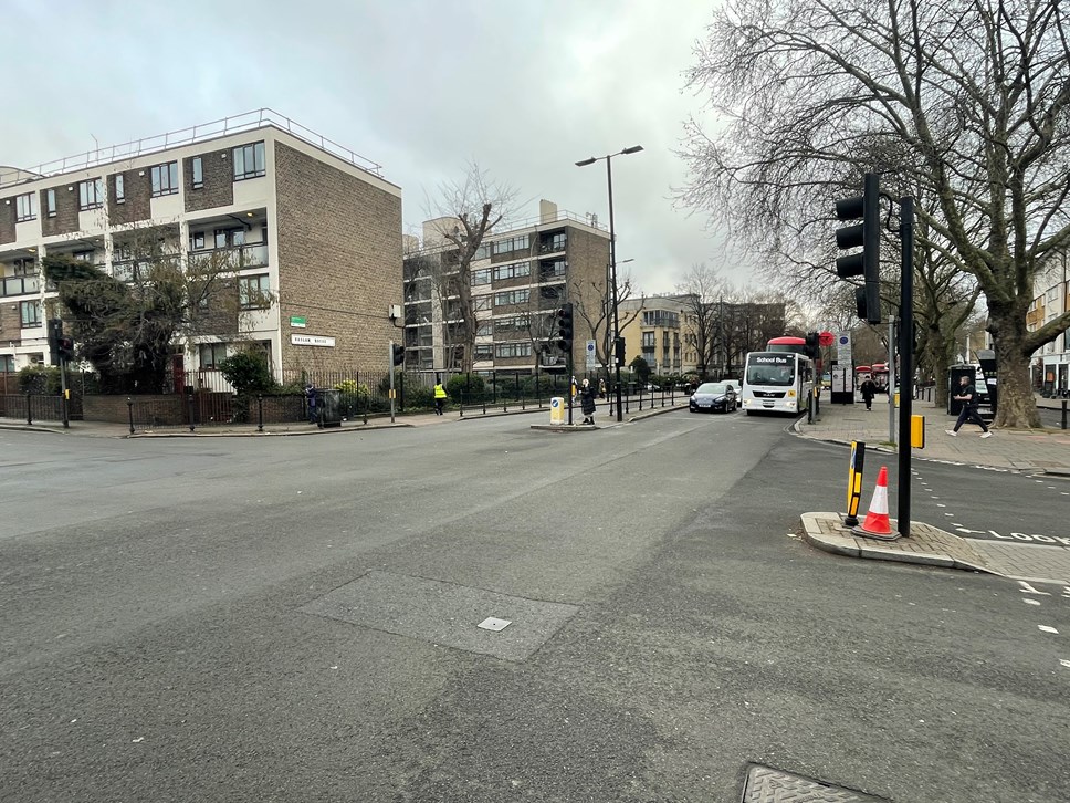 A photo taken from the junction of Essex Road and New North Road, showing vehicles queuing at lights and people crossing roads