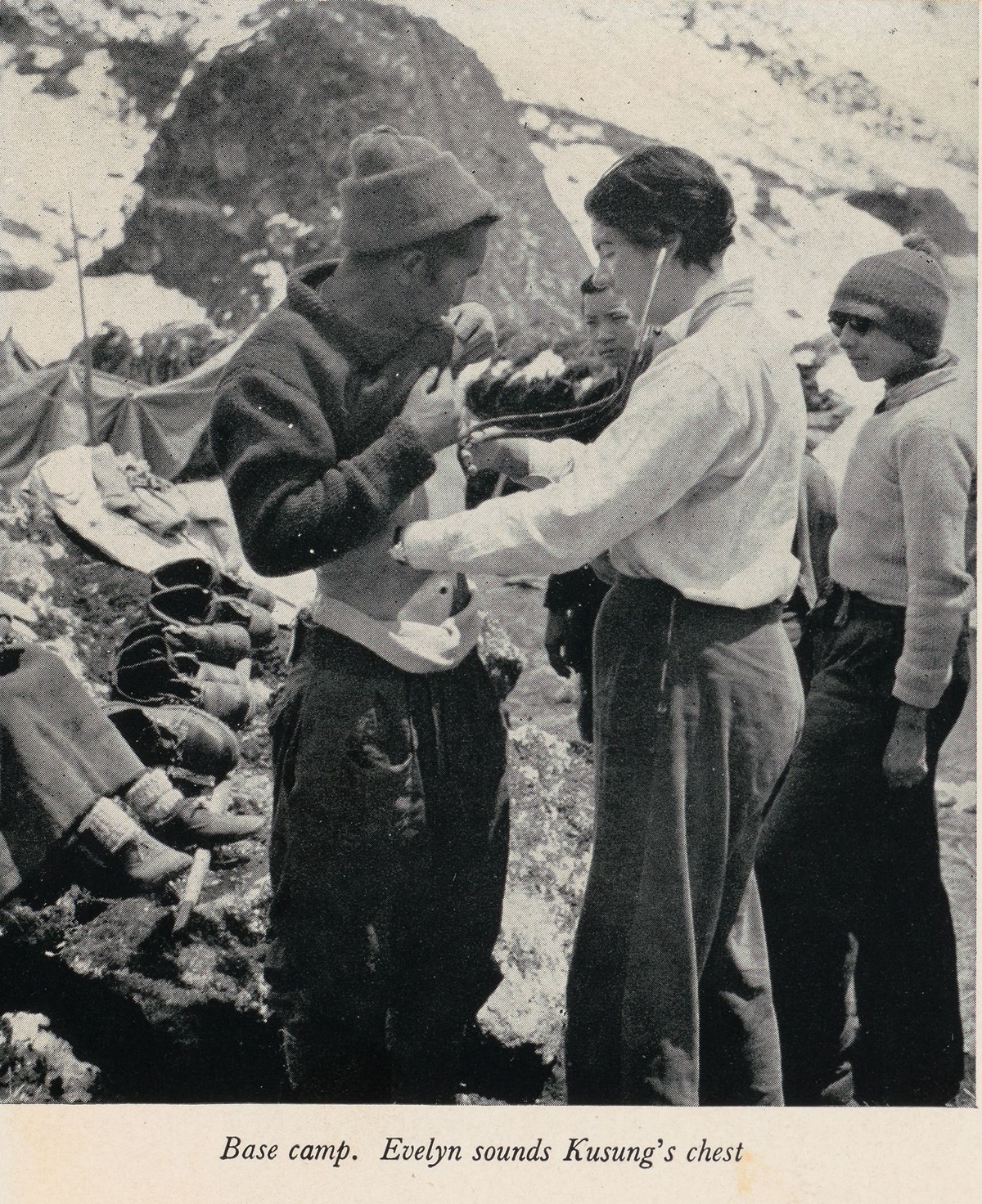 Evelyn McNicol, who was part of the first all-female expedition to the Himalayas in 1955, checks the health of a sherpa.