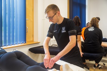 Male student at University of Cumbria carrying out a sport rehabilitation massage in a campus clinic