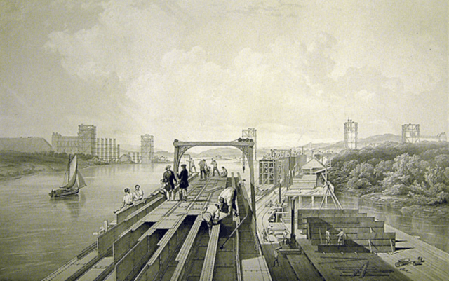 Britannia Bridge over taken during its construction in 1848 showing partially completed piers in background - credit NRM York: Britannia Bridge over taken during its construction in 1848 showing partially completed piers in background - credit NRM York