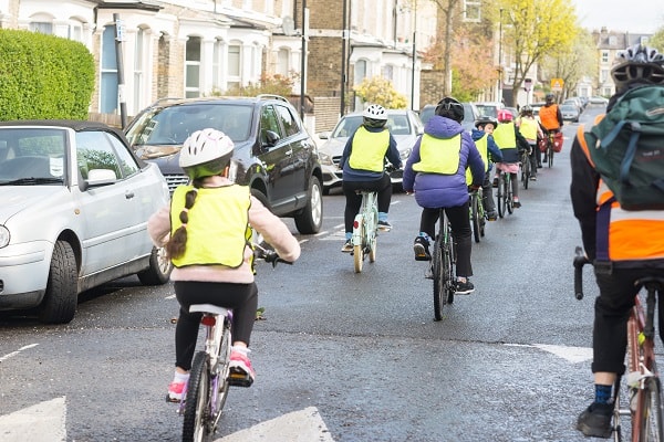 A group of children in hi-visibility jackets cycling in Islington