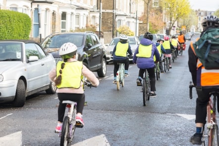A group of children in hi-visibility jackets cycling in Islington