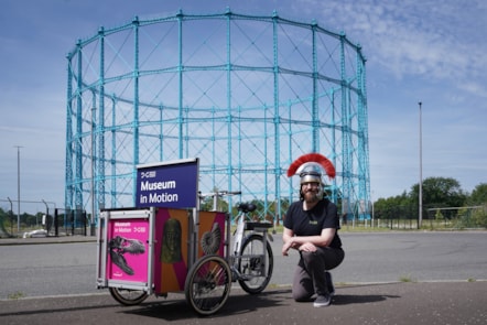 Enabler David Cree kneels beside National Museums Scotland's new cargo bike, Museum in Motion.