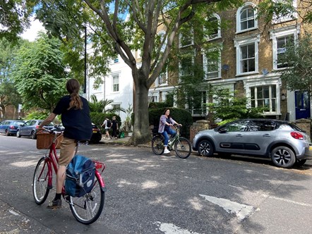 Two people cycle in an Islington street