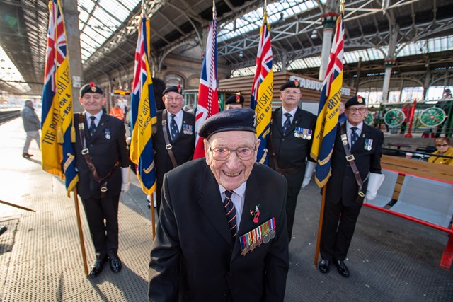 Ernest Horsfall smiling in front of standard bearers from the Royal British Legion's Preston branch
