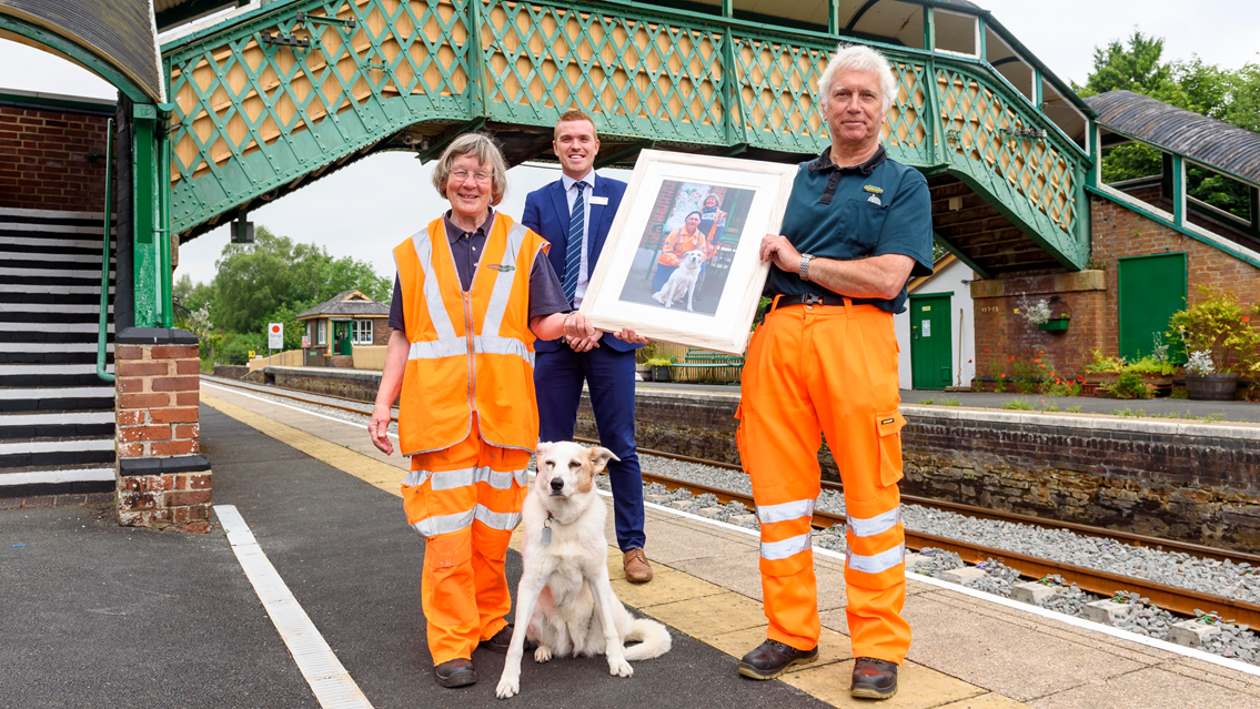 Tom and Sue Baxter with beloved dog Rosie and Christian Irwin of Network Rail: Tom and Sue Baxter of the Dartmoor Railway Association were presented with a framed photo by Christian Irwin, Network Rail industry programme director.