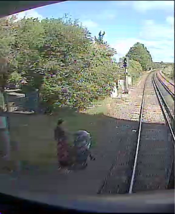 Shocking image caught on camera of a woman attempting to cross the track at Hilsea, near Portsmouth, with a pushchair: Hilsea