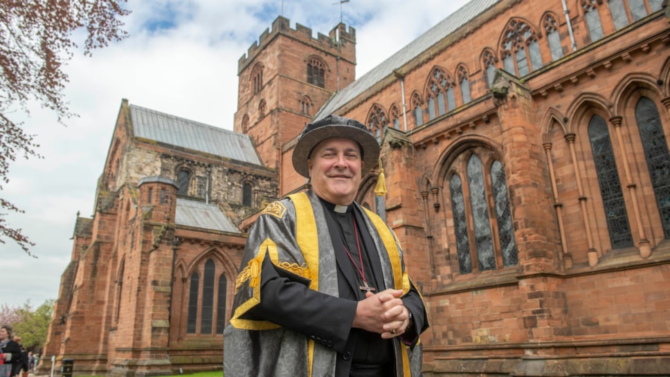 Archbishop of York Stephen Cottrell in academic robes outside Carlisle Cathedral at his inauguration as Chancellor of University of Cumbria