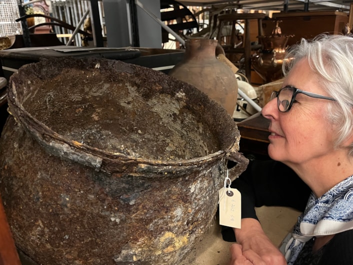Cauldron: Curator Kitty Ross with the mysterious iron cauldron at the Leeds Discovery Centre.
The cauldron was originally discovered in a cellar in Chapeltown in 2012 after workers came to investigate a peculiar dripping sound which the resident could not locate.
Removing a wall, they discovered what appeared to be a petrified object which was later identified as a metal cauldron, sealed behind the wall in what is believed to have been part of an ancient practice designed to protect the house and its residents from malign or supernatural forces.