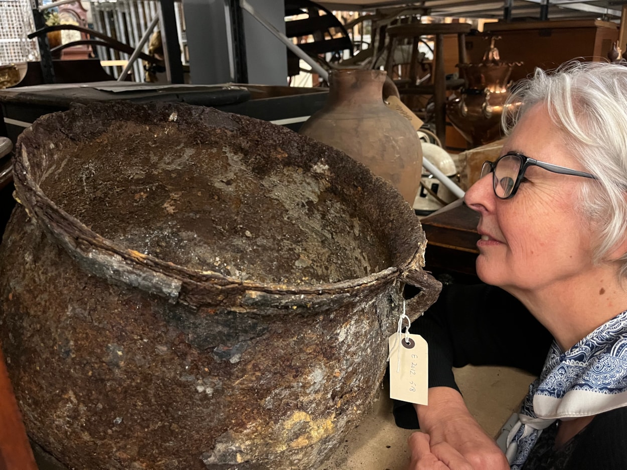 Cauldron: Curator Kitty Ross with the mysterious iron cauldron at the Leeds Discovery Centre.
The cauldron was originally discovered in a cellar in Chapeltown in 2012 after workers came to investigate a peculiar dripping sound which the resident could not locate.
Removing a wall, they discovered what appeared to be a petrified object which was later identified as a metal cauldron, sealed behind the wall in what is believed to have been part of an ancient practice designed to protect the house and its residents from malign or supernatural forces.