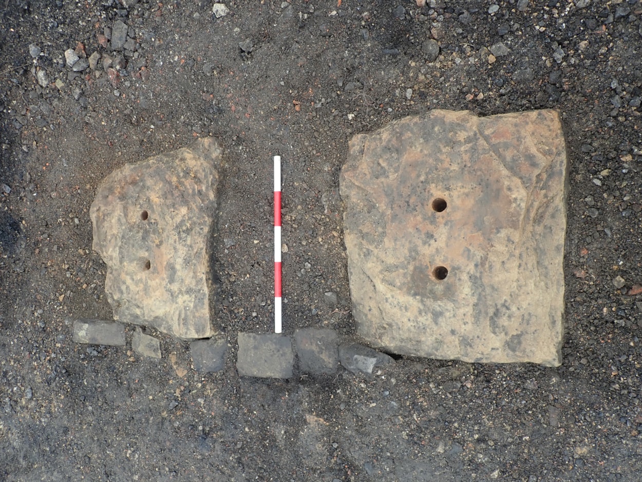 Train station excavation: Huge stone sleepers, used to secure tracks in the years before wooden sleepers were employed and which still show the holes where railway spikes were driven into them.