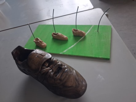 Maquette of football club sculpture and bronze effect football boot replica