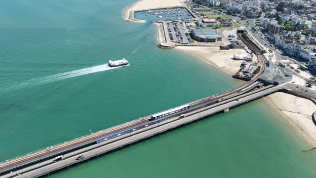 Isle of Wight railway history celebrated after full Island Line services resume: A Hovercraft and Island Line train make their way towards Ryde Esplanade