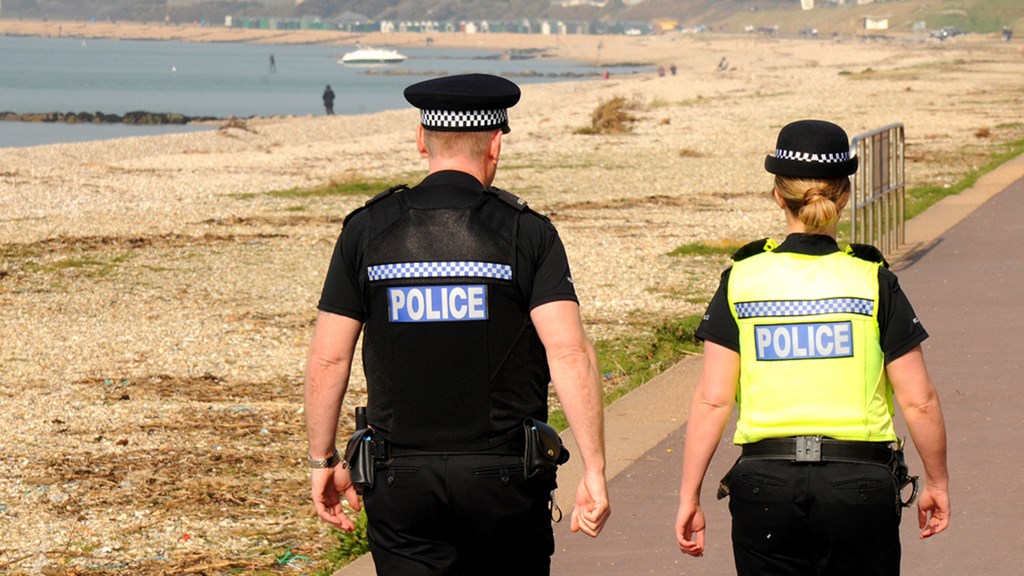 Two officers walking on a beachfront - Hero Image