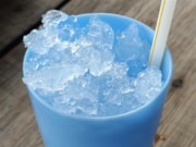A blue plastic sup with ice in: A blue plastic sup with ice in