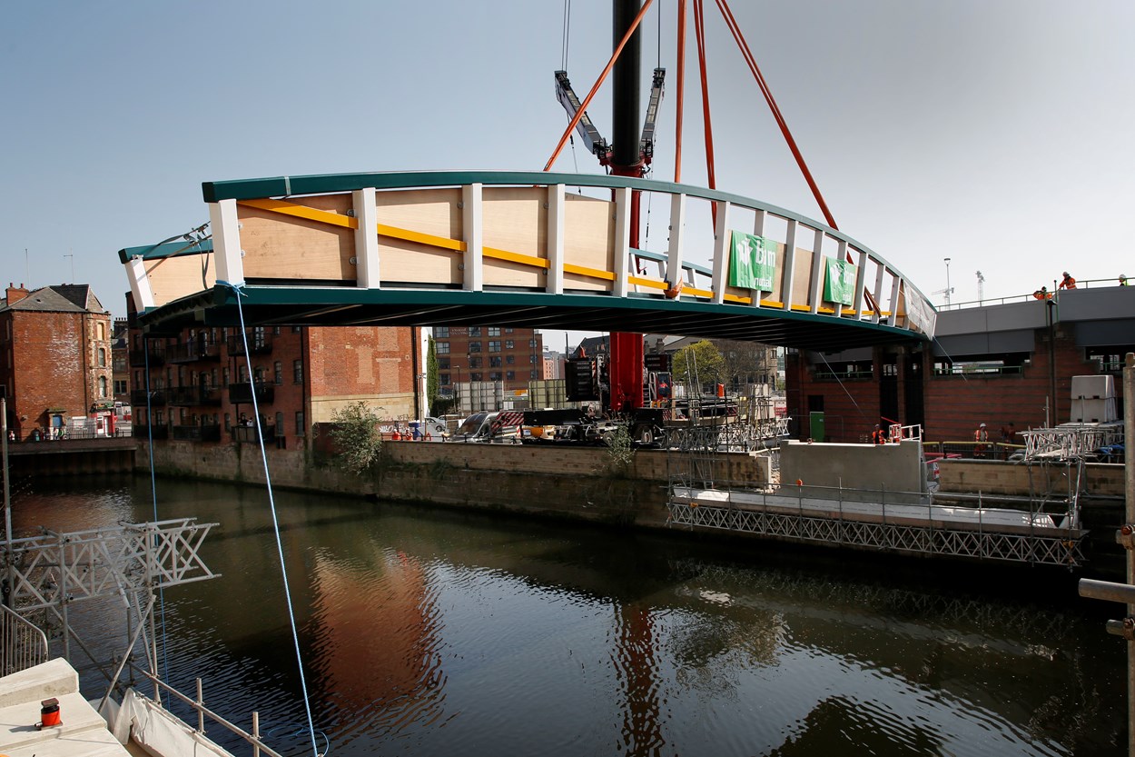 David Oluwale bridge installation: The David Oluwale bridge is lifted into place over the River Aire in Leeds. Engineers working on the David Oluwale bridge completed one of the project’s major milestones over the weekend, with cranes carefully placing the 40 tonne structure over the river where it will connect Sovereign Street to Water Lane. Credit BAM Nuttall.