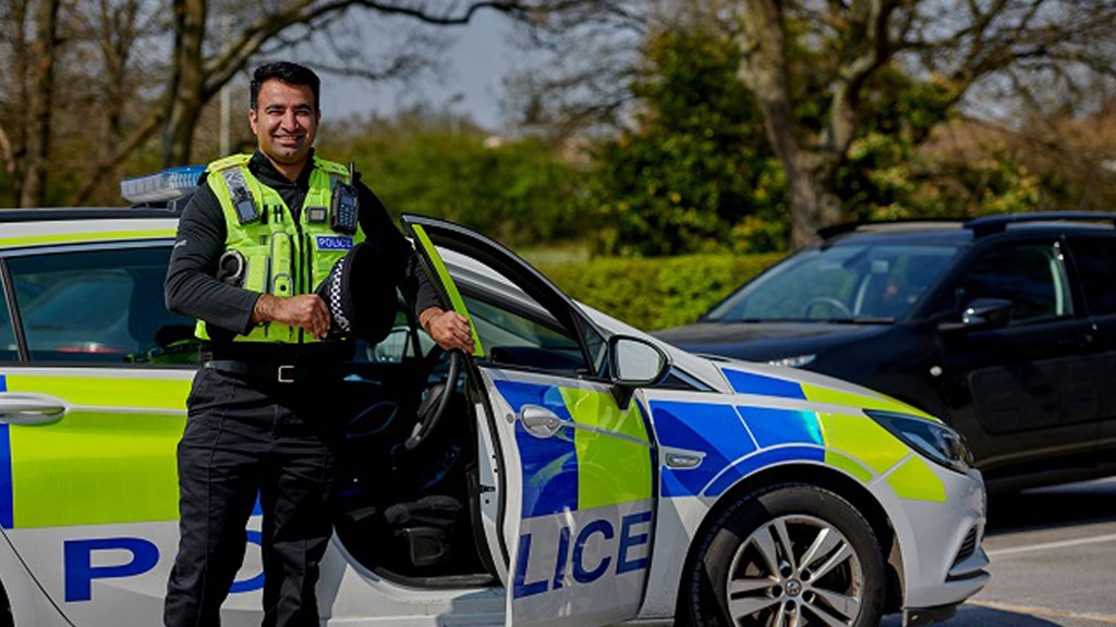 Officer stood outside police car - Hero Image