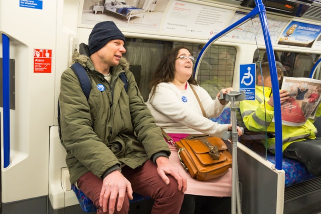 TfL Image - Customers using Please offer me a seat badges and priority seating