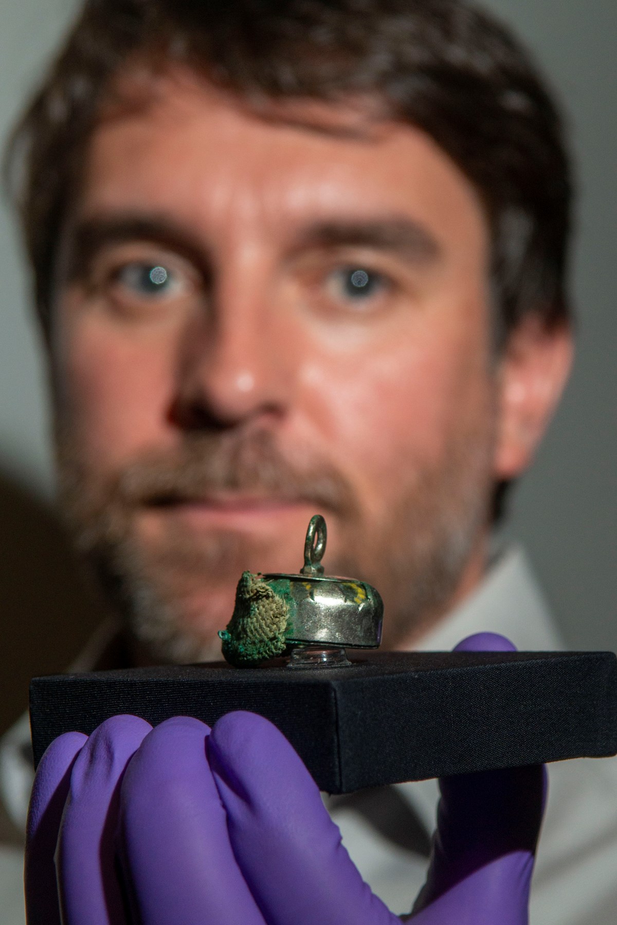 Dr Martin Goldberg and a relic bead pedant with traces of rare textiles from the Galloway Hoard. Photo © Aberdeen City Council (2)