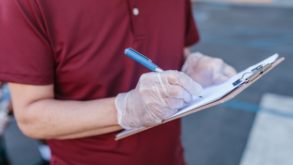 Person in gloves with clipboards