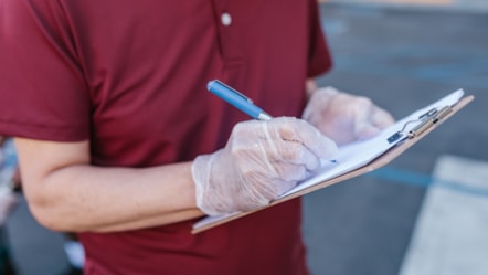 Person in gloves with clipboards