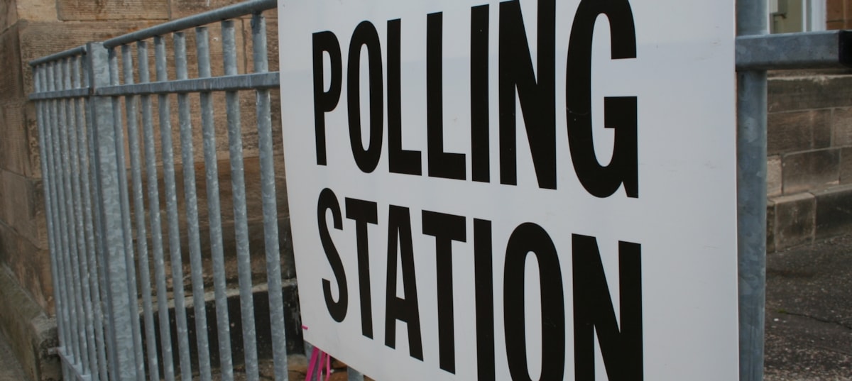 Polling station sign on railings.