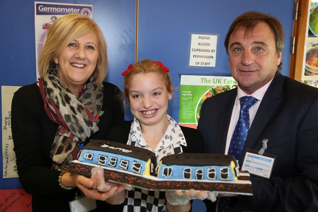 Deputy head Julie King and pupil Shannon present Barry Dilks with a thank-you cake: Deputy head of Manor Green College Julie King and pupil Shannon present Barry Dilks with a thank-you cake