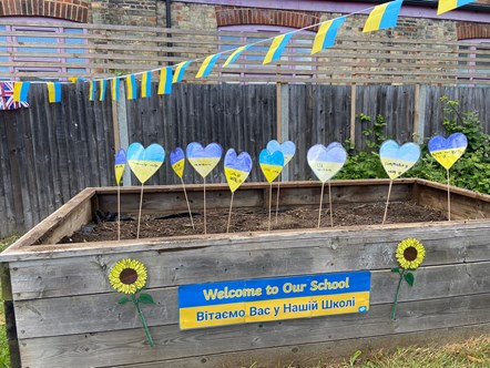 A raised bed displays hearts in the colours of the Ukraine flag with messages of solidarity, at Christ The King Catholic Primary School