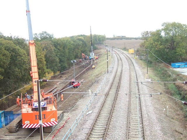 WRABNESS LANDSLIP: HARWICH BRANCH LINE REOPENS SIX DAYS EARLY AFTER HEROIC EFFORTS: Copperas Wood embankment - new piling