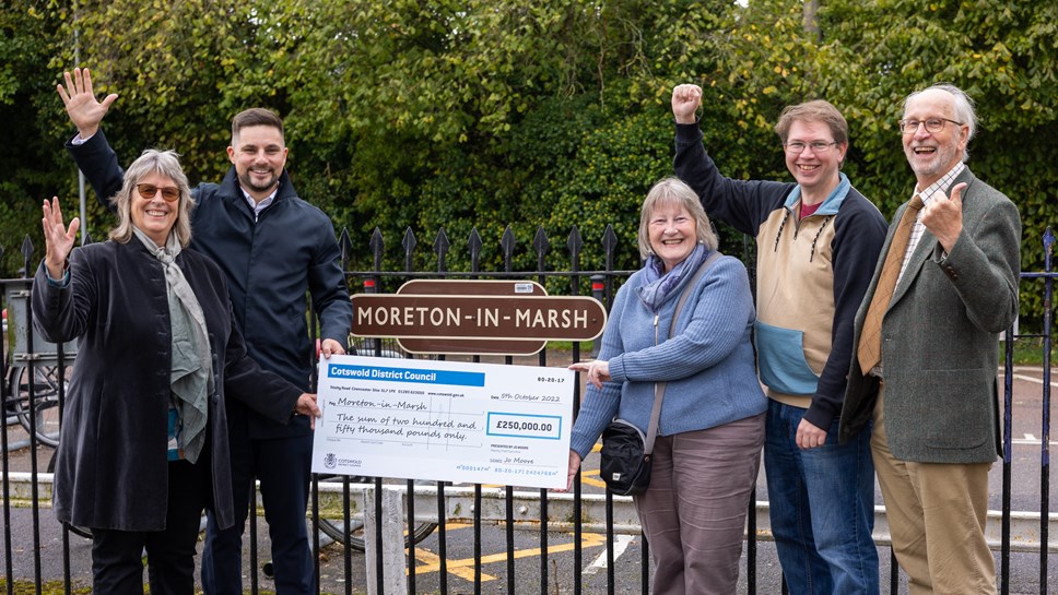Cotswold District Council presented Moreton-in-Marsh Town Council with a cheque for a quarter of a million pounds to improve the transportation and social wellbeing of the town.
Left to right: Cllr Juliet Layton and Cllr Joe Harris from Cotswold District Council. Cllr Eileen Viviani and Cllr Clive Webster from Moreton-in-Marsh Town Council and local resident Angus Jenkins.