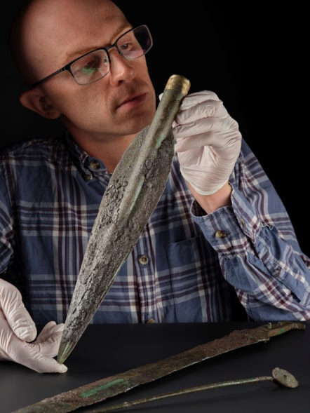 National Museums Scotland curator Dr Matthew Knight examines the Carnoustie Hoard. Photo © National Museums Scotland 2