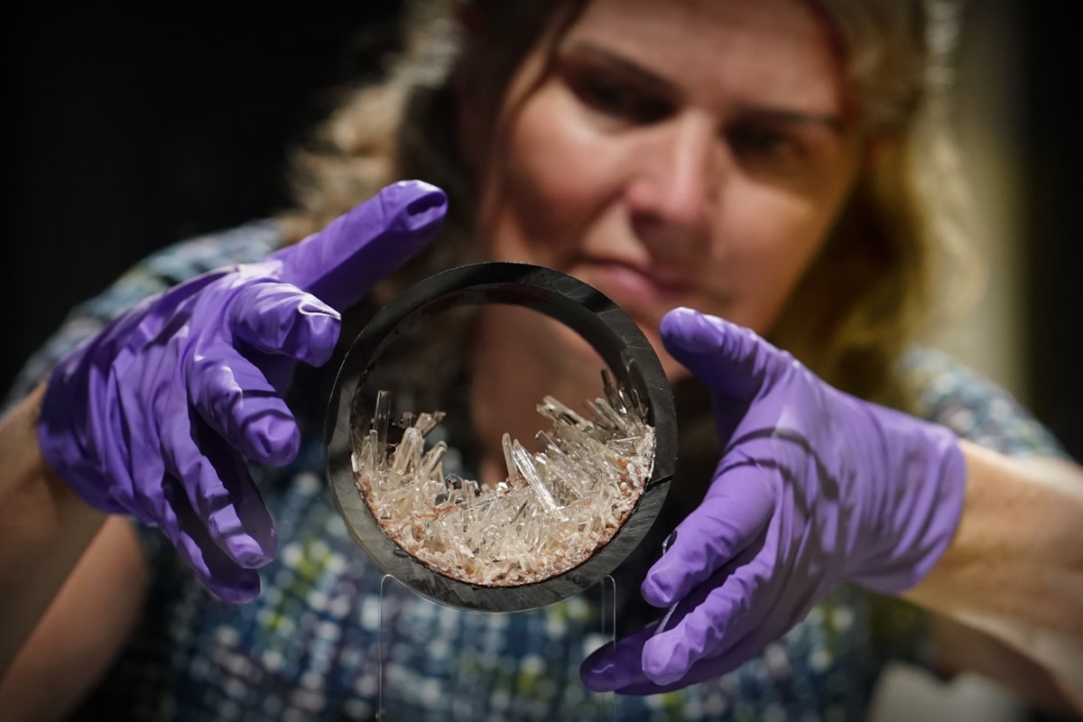 Dr Rachel Walcott, Principal Curator of Earth Systems, with a plastic pipe containing gypsum crystals, image copyright Stewart Attwood