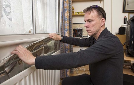 A stock image of a resident installing a radiator